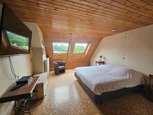 a bedroom with a bed and a desk in a room at La Source d'Arimont in Malmedy