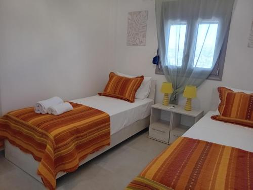 a bedroom with two beds and a window at Villa Jodi Hilltop in Pitsidia
