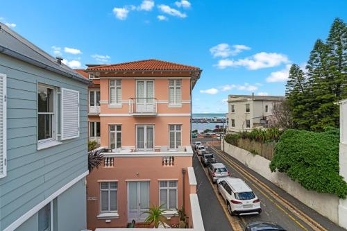 an apartment building with cars parked on a street at Kalk Bay Condo at The Majestic in Kalk Bay