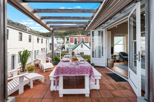 an outdoor patio with a table and benches at Kalk Bay Condo at The Majestic in Kalk Bay
