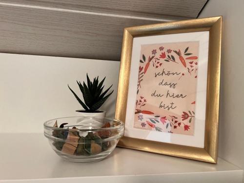 a picture and a bowl on a shelf with a plant at Exklusiver Seetraum am Attersee direkt am See in Litzlberg