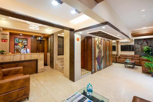 a lobby of a hotel with a man standing at the counter at Hotel Kalpana Palace, Mumbai in Mumbai