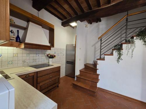 eine Küche mit einer Treppe in der Mitte einer Küche in der Unterkunft Leonina Country House by Francigena Apartments in Casetta
