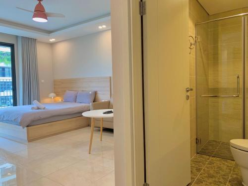 a bedroom with a bed and a bathroom with a shower at Vinhomes D'Capitale - Luka homes in Hanoi