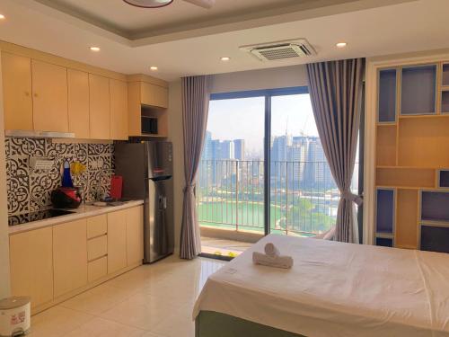a kitchen with a bed and a large window at Vinhomes D'Capitale - Luka homes in Hanoi