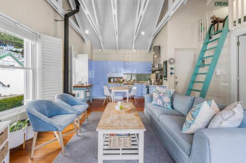 a living room with a couch and chairs and a table at Kalk Bay Condo at The Majestic in Kalk Bay