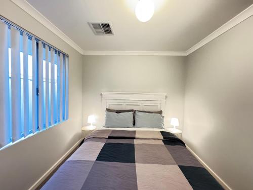 a bedroom with a bed and a large window at Blissful Modern Home in Perth
