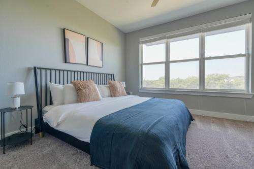 a bedroom with a large bed and two windows at Blueground Austin pool nr Walnut Creek ATX-258 in Austin