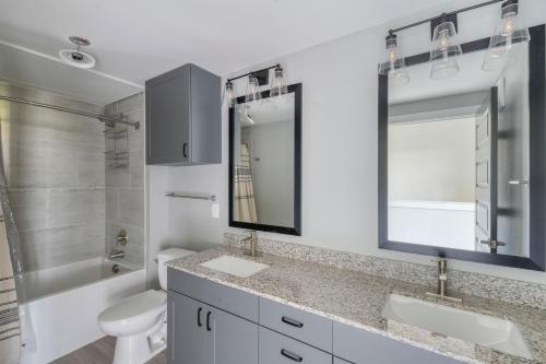 a bathroom with a sink and a toilet and a mirror at Blueground Austin pool nr Walnut Creek ATX-258 in Austin