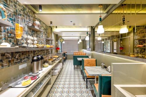 a restaurant with tables and chairs in a kitchen at Hotel Kalpana Palace, Mumbai in Mumbai