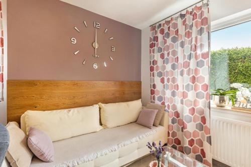 a clock on a wall above a couch in a room at Ferienwohnung Sonnenblick und Relax in Nieder-Röhre