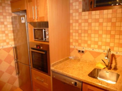 a kitchen with a sink and a microwave at Casa Atheba in La Iglesuela del Cid