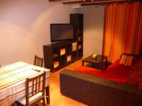 a living room with a couch and a flat screen tv at Casa Atheba in La Iglesuela del Cid