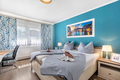 a hotel room with two beds with blue walls at Ferienwohnung Sonnenblick und Relax in Nieder-Röhre