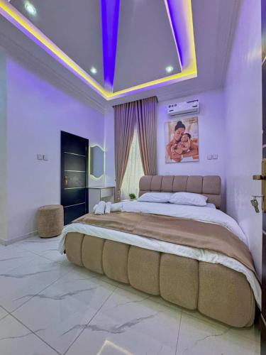 a bedroom with a large bed with a purple ceiling at luxury 3bed rooms duplex lekki Lagos nigeria in Lekki