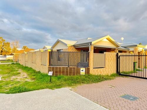a row of houses behind a fence at Blissful Modern Home in Perth