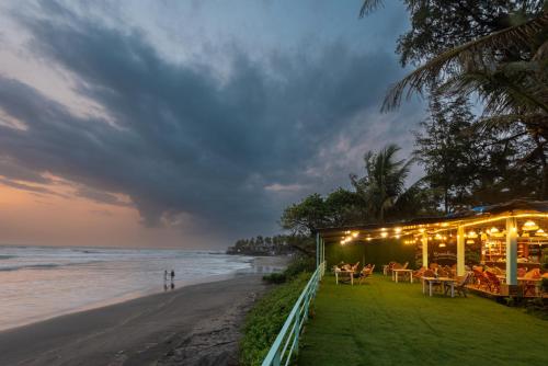 a restaurant on the beach at sunset at Amadi Beach Front Resort in Mandrem