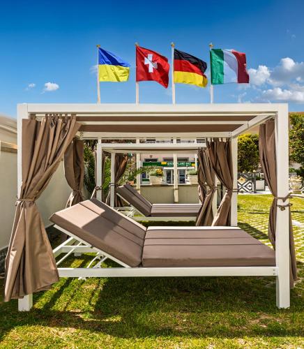 a bed with flags on top of it in a yard at Hotel Harmony-Smile in Lido di Camaiore