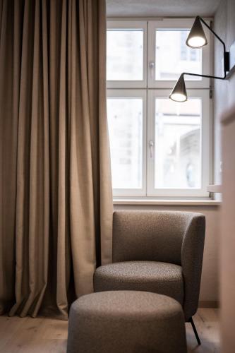 a room with a chair and a window at HOTEL & SPA Goldene Rose in Dinkelsbühl