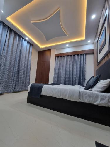 a bedroom with a large bed and curtains at The Regal Vistas Hotel and Banquet in Siliguri
