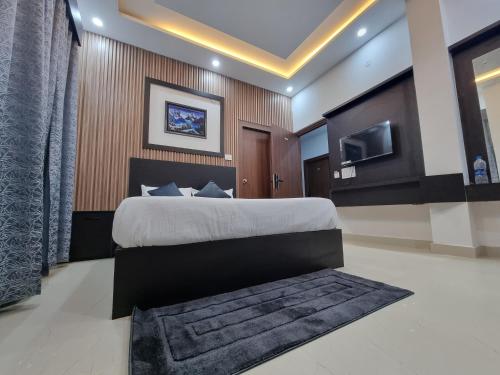 a bedroom with a large bed and a tv at The Regal Vistas Hotel and Banquet in Siliguri