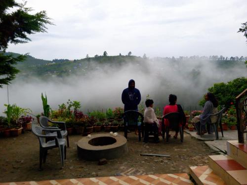 a group of people standing around in the mist at Bison Valley View Stay in Kodaikānāl