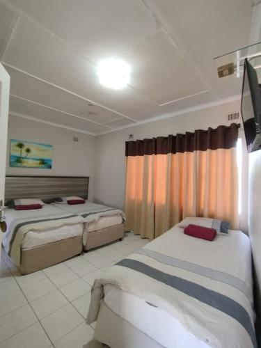 a bedroom with two beds and a window in it at Faraaz BnB in Ladysmith