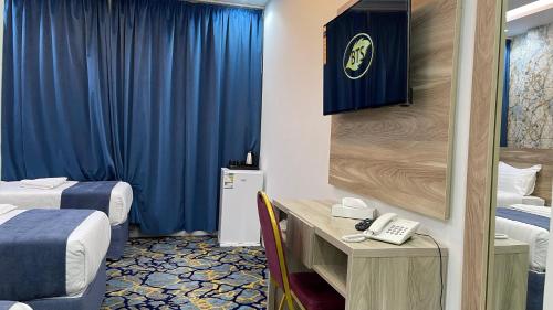 a hotel room with two beds and a telephone at فندق برادايس لاند الزهراء Paradis Land Hotel ALzhra in Az Zahrāʼ