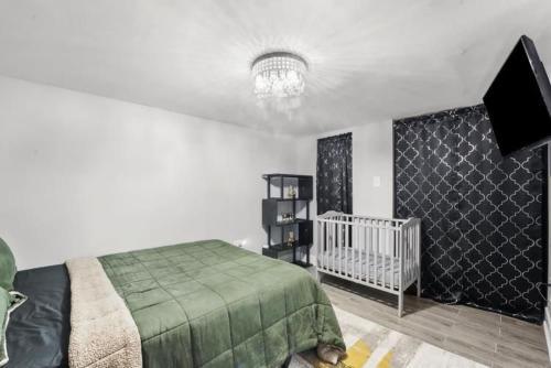 a bedroom with a bed and a tv and a crib at Hamaline Luxury Guest House in Chicago