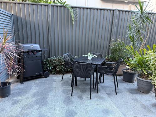 a patio with a table and chairs and a grill at SeaSide Serenity - beach 200m in Mudjimba
