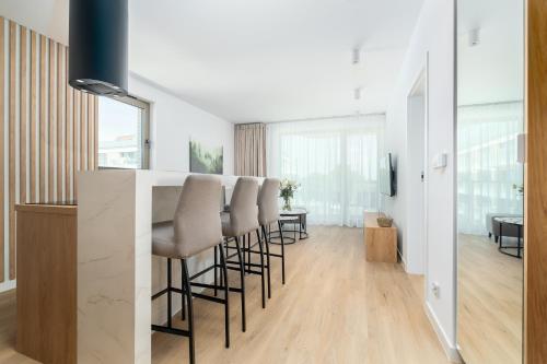 a kitchen and living room with a bar with stools at Sarbinove City Apartments in Sarbinowo
