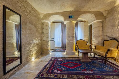 a room with two chairs and a table and a rug at Kayatas Cave Suites in Goreme