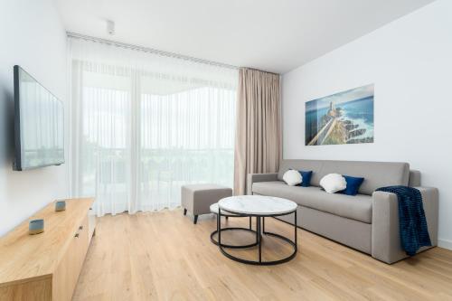 a living room with a couch and a table at Sarbinove City Apartments in Sarbinowo