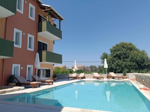 a swimming pool in front of a building at Porto Nirikos Lefkada in Lefkada
