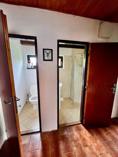 a bathroom with a toilet and a bathroom with a door at Chata Emma Frymburk in Frymburk