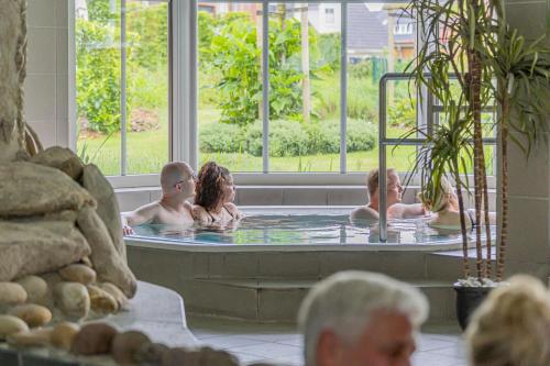 a group of people in a hot tub at Köhlers Forsthaus Wellness & Genuss Hotel in Aurich