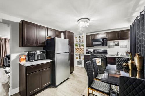 a kitchen with wooden cabinets and a stainless steel refrigerator at Hamaline Luxury Guest House in Chicago