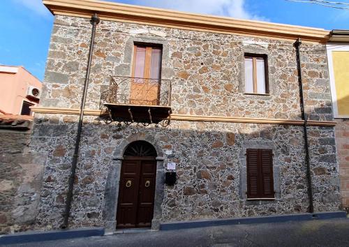 a stone building with a door and a balcony at B&B Su PRESSIU in Narbolia