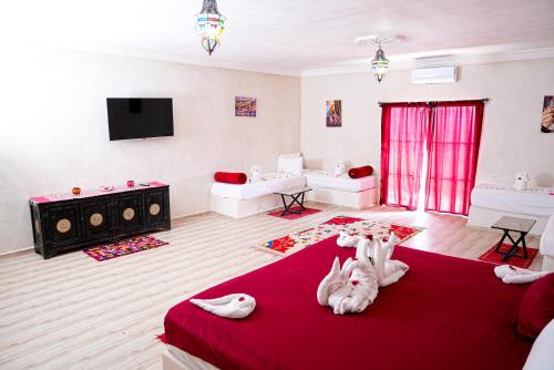 a living room with two dogs laying on a red blanket at Les Jardins d Amizmiz 6 piscines in Marrakech