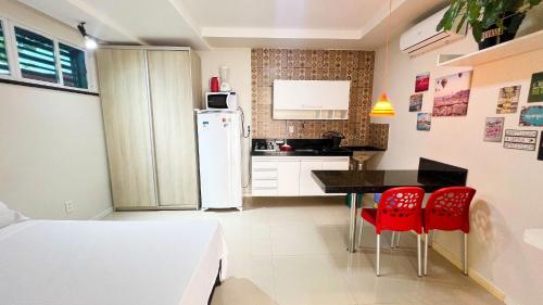 a kitchen with a table and two red chairs at Requinte pertinho do mar da Atalaia in Santa Maria