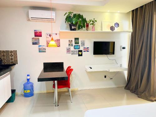 a room with a desk and a table with a laptop at Requinte pertinho do mar da Atalaia in Santa Maria