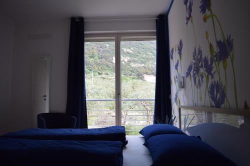 a bedroom with two beds and a large window at "CASABANA" - relax tutto l'anno - giardino - piscina Top in Malcesine