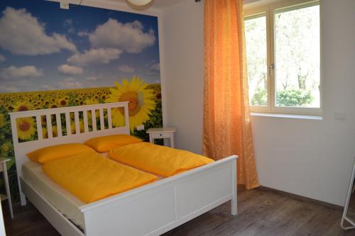 a bedroom with a bed with orange sheets and a sunflower wall at "CASABANA" - relax tutto l'anno - giardino - piscina Top in Malcesine
