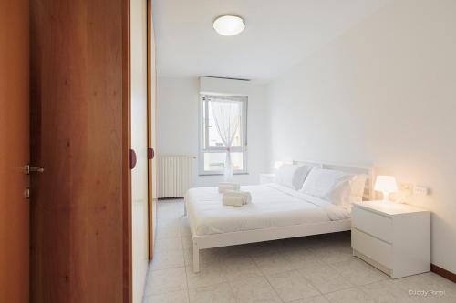 a white bedroom with a white bed and a window at BGY Colorful Home in Grassobbio