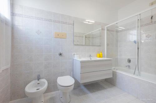 a white bathroom with a toilet and a sink at BGY Colorful Home in Grassobbio