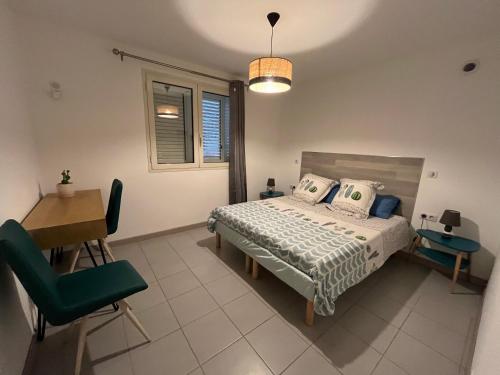 une chambre avec un lit, un bureau et une chaise dans l'établissement F2 REZ DE VILLA ENTRE MER ET MONTAGNE, à San-Martino-di-Lota