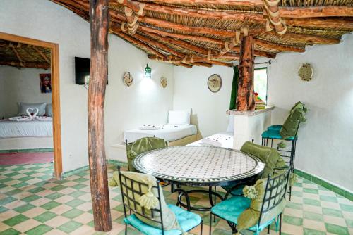 a dining room with a table and chairs in a room at Les Jardins d Amizmiz 6 piscines in Marrakech