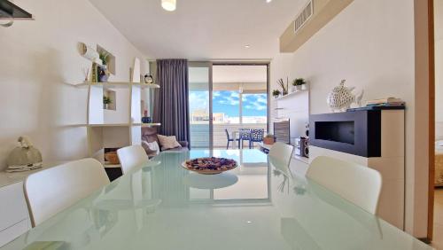 una sala da pranzo con un tavolo di vetro e sedie bianche di Suite Gallipoli con vista mare da 4 posti e wifi a Gallipoli