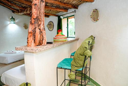 a frog sitting on two chairs in a room at Les Jardins d Amizmiz 6 piscines in Marrakech