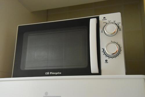 a microwave oven sitting on top of a refrigerator at Cozy apartment to enjoy all year round in Latas